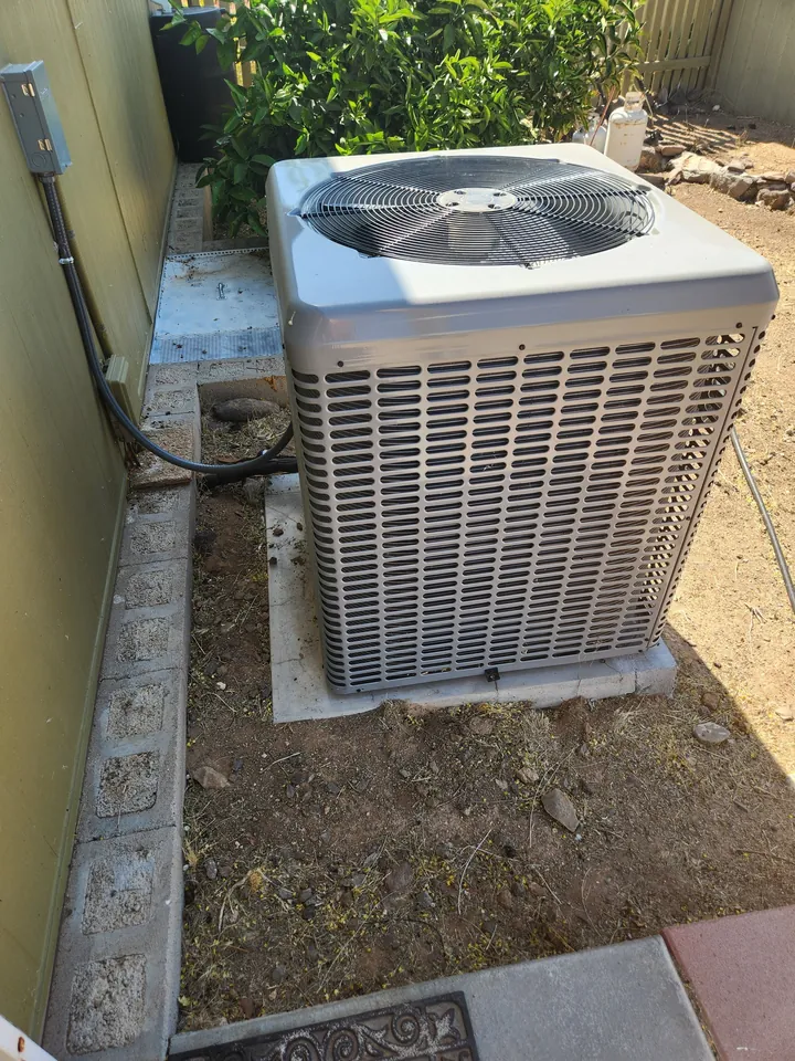 AC condenser in a side yard beside the house