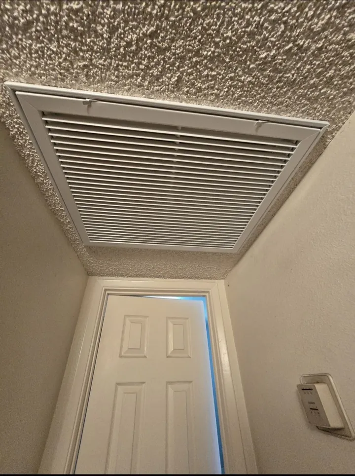 Ceiling return air grille in a hallway