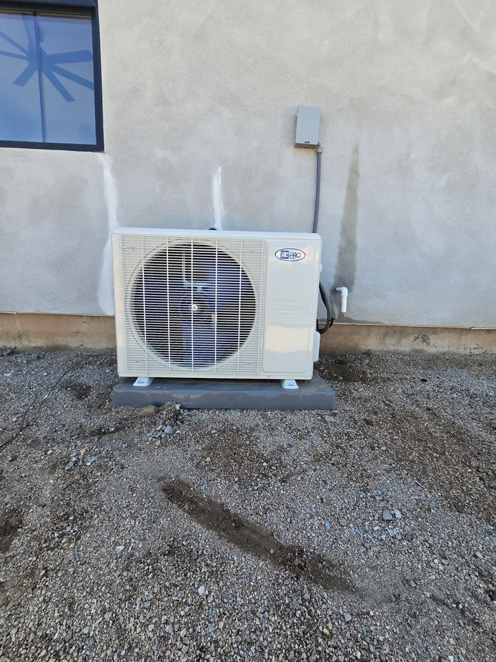 Mini split outdoor unit mounted on a stucco wall