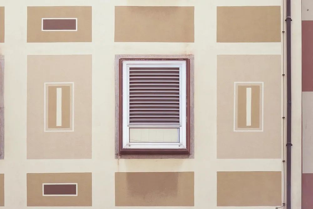 Ventilation grille set into a beige exterior wall
