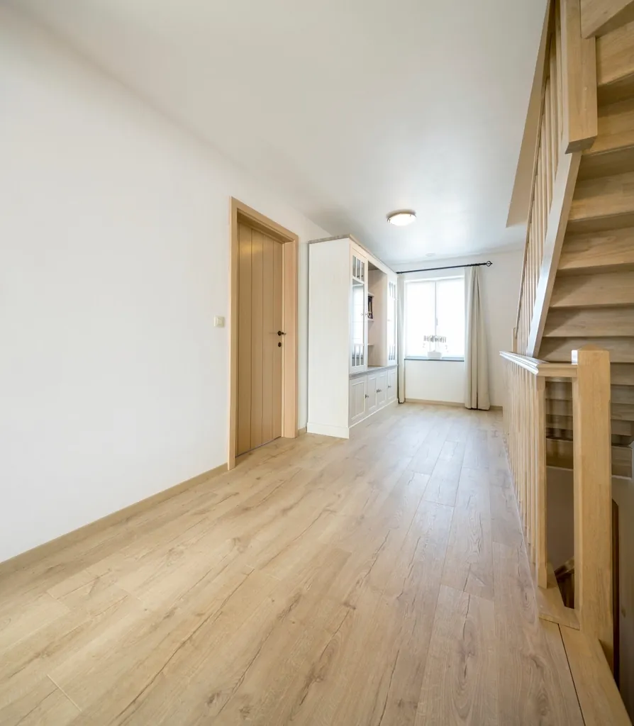 Bright hallway with wood floors and a staircase